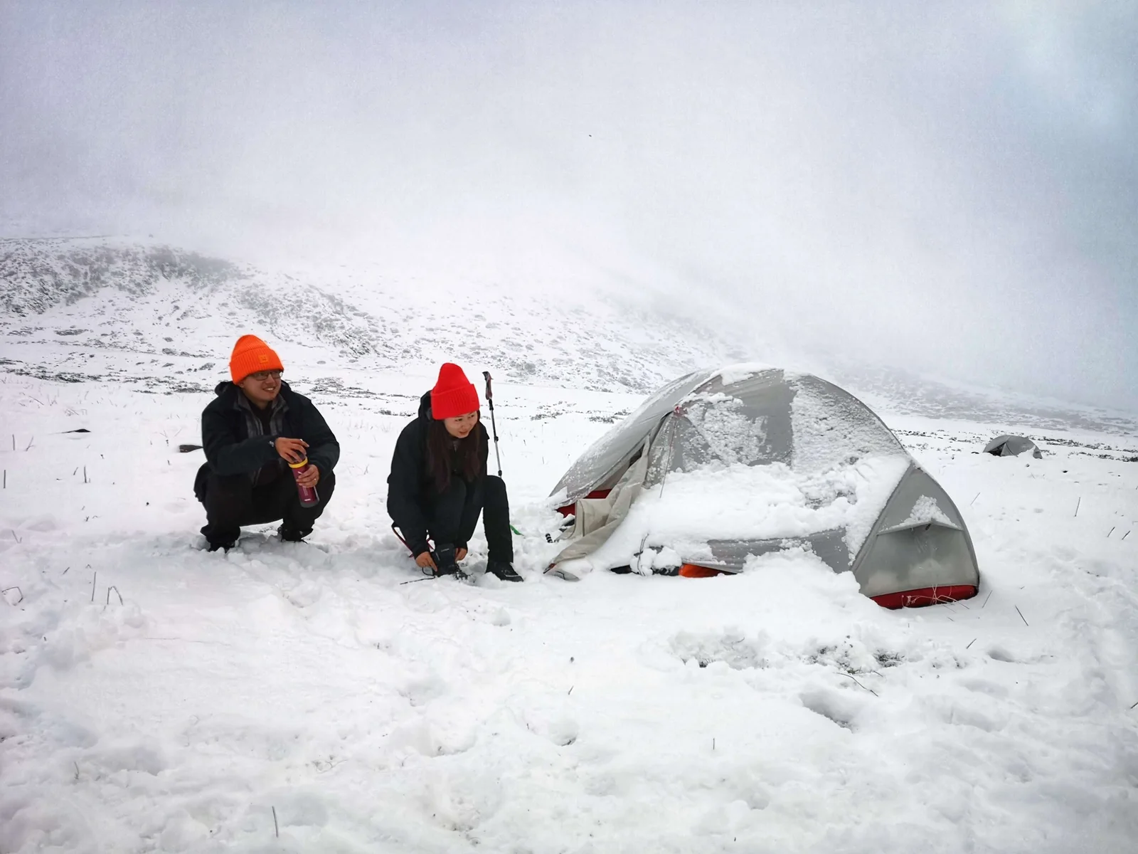 雪地露营时的合影，身后是一顶帐篷
